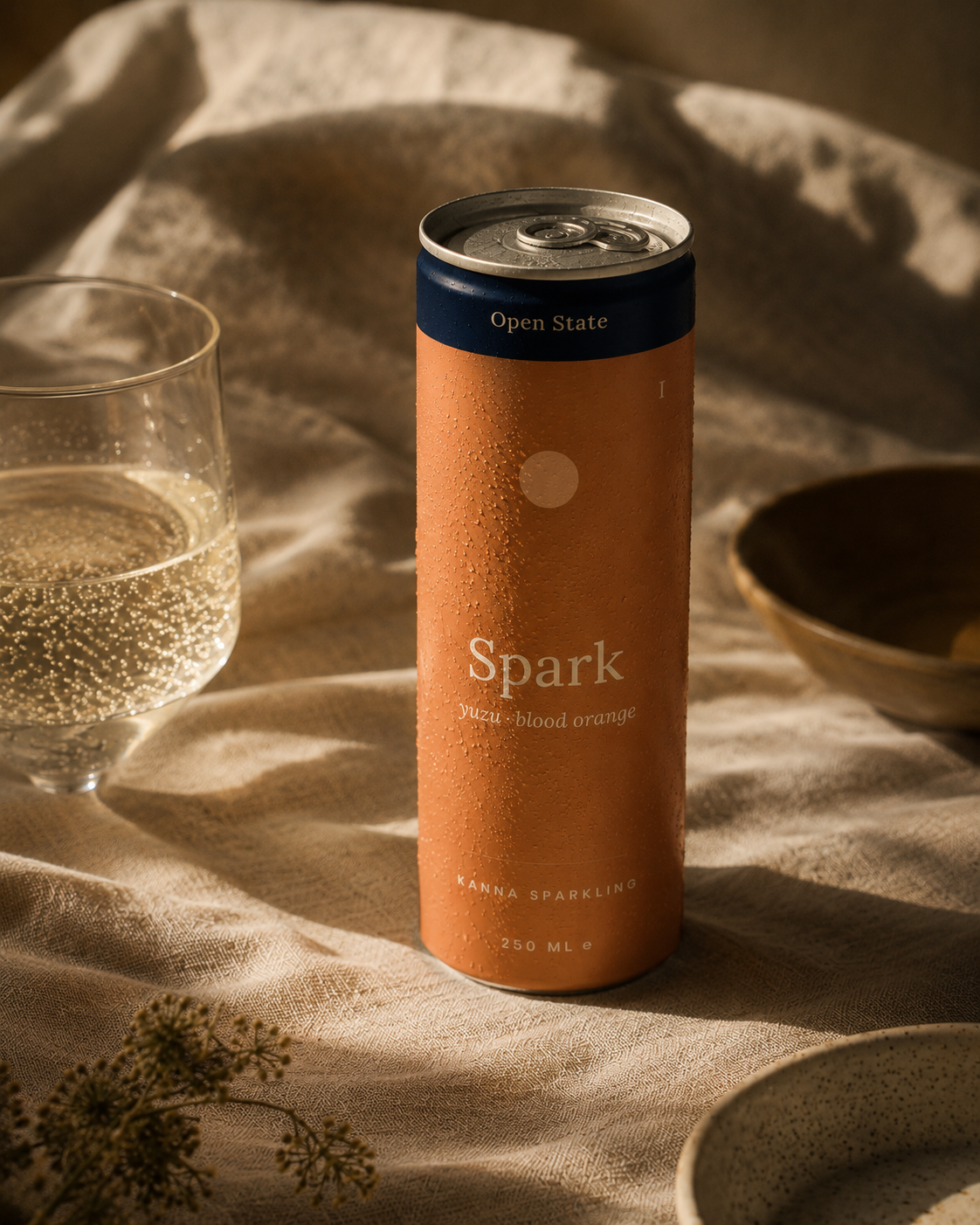 Open State Spark can styled on warm linen beside a glass